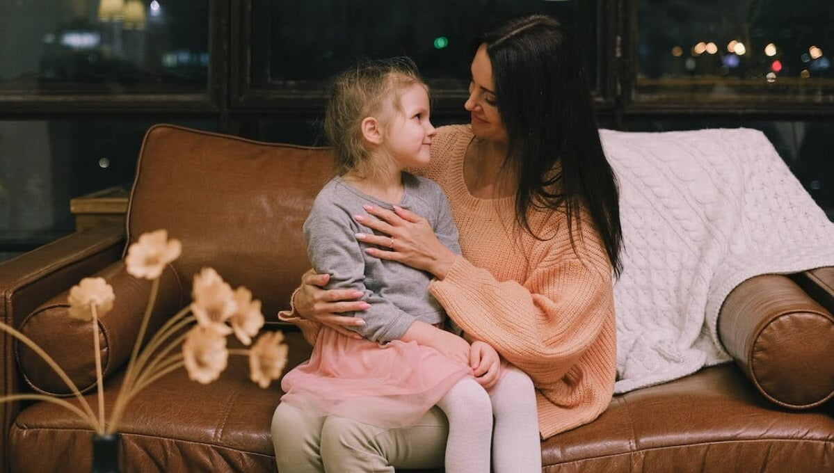 mom and daughter on a leather sofa